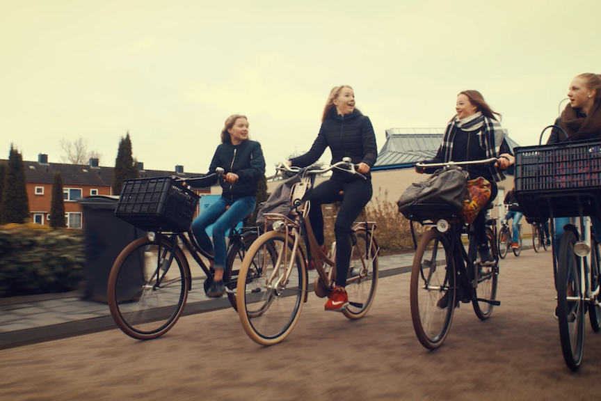 Bild aus dem Film: Fahrradfahrende Mädchen Bild aus dem Film: Vier Teenager-Mädchen fahren nebeneinander Fahrrad und unterhalten sich.